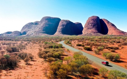 car driving on highway towards rocks 