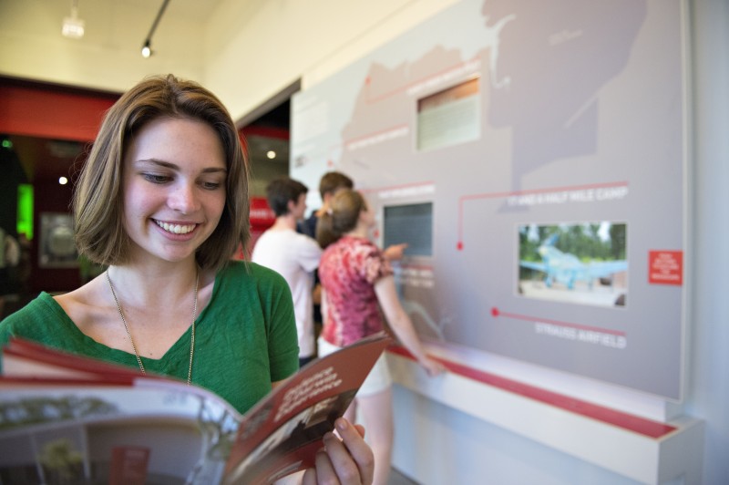 Girl reading brochure at defence of darwin tourism