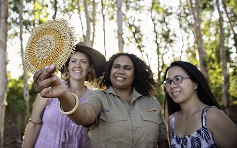 Tourists and tour guide looking at handmade crafts