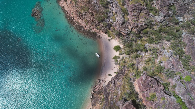 aerial image of ocean and land with one boat